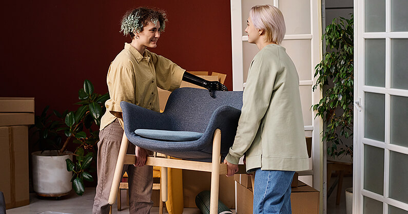 2 Women moving a chair