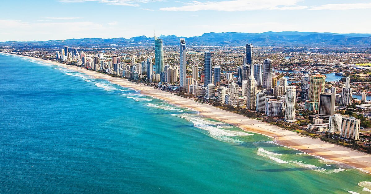 Aerial view of Gold Coast coastline in afternoon with beautiful beach and distant mountains