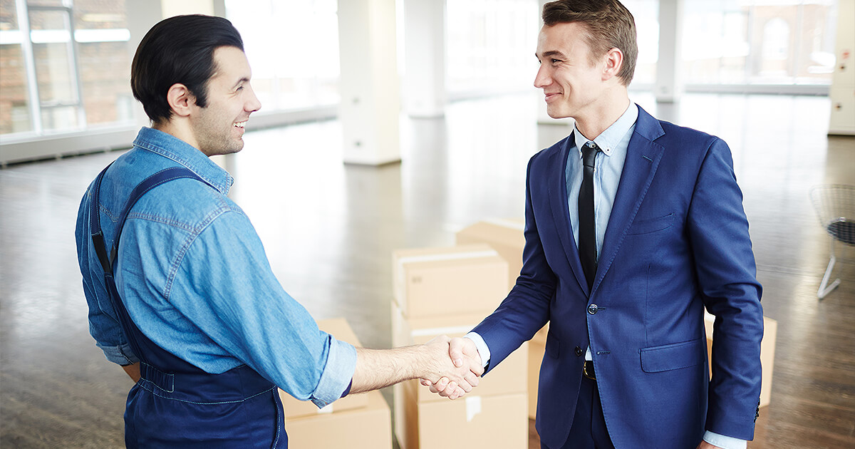 Business owner and removalist shake hands after corporate moving