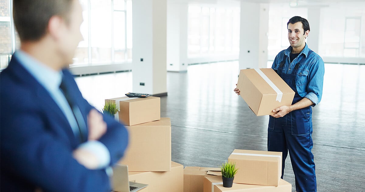Office removalist moving boxes into new modern office