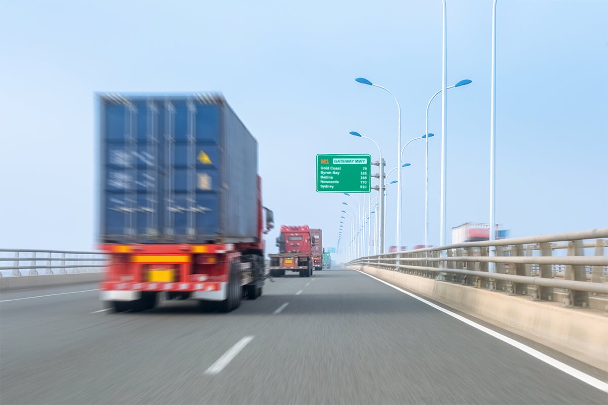 Blurred removalist truck drives over large bridge