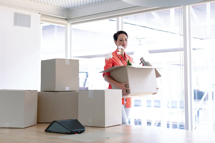 Business woman moves boxes into new office