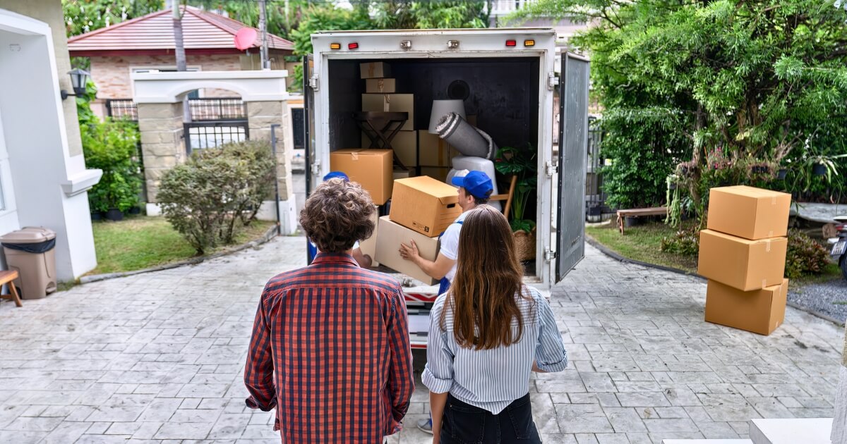 Couple looking at moving truck being unpacked