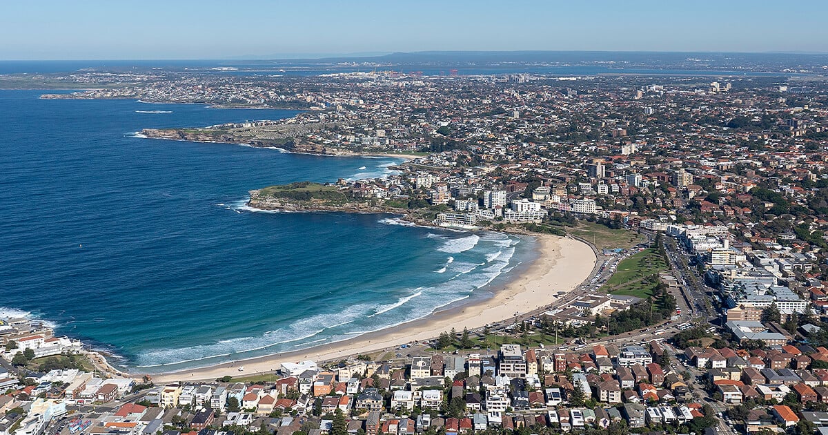 Aerial view of Bondi Beach in Sydney with residential houses surrounding and in the distance