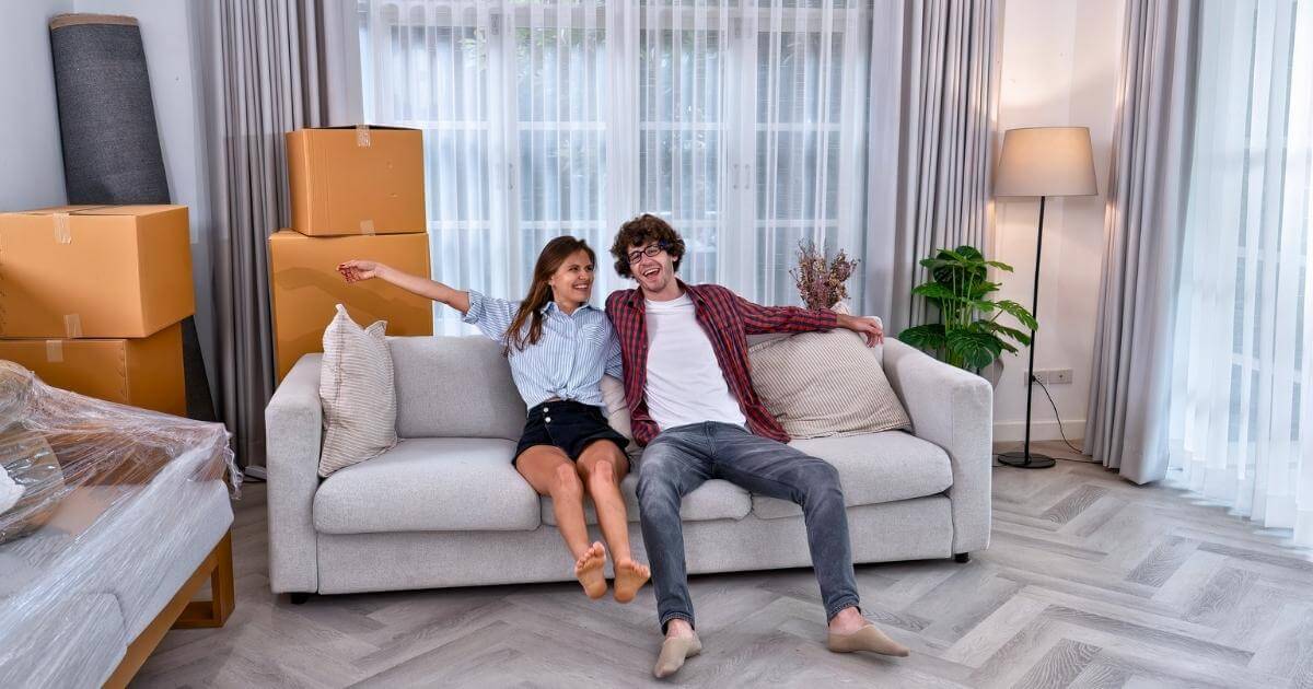 Happy couple sitting on new couch after interstate furniture move