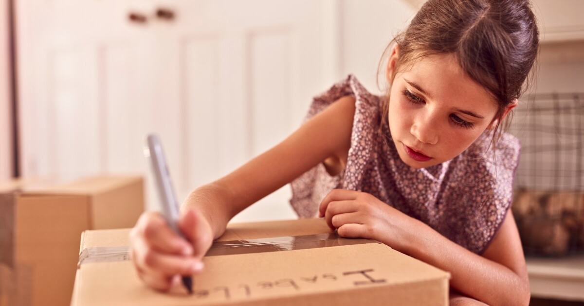 Girl labelling a box which is a great long-term storage tip