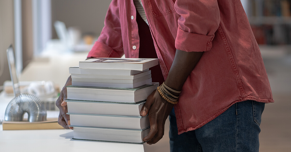 Man moving a pile of books