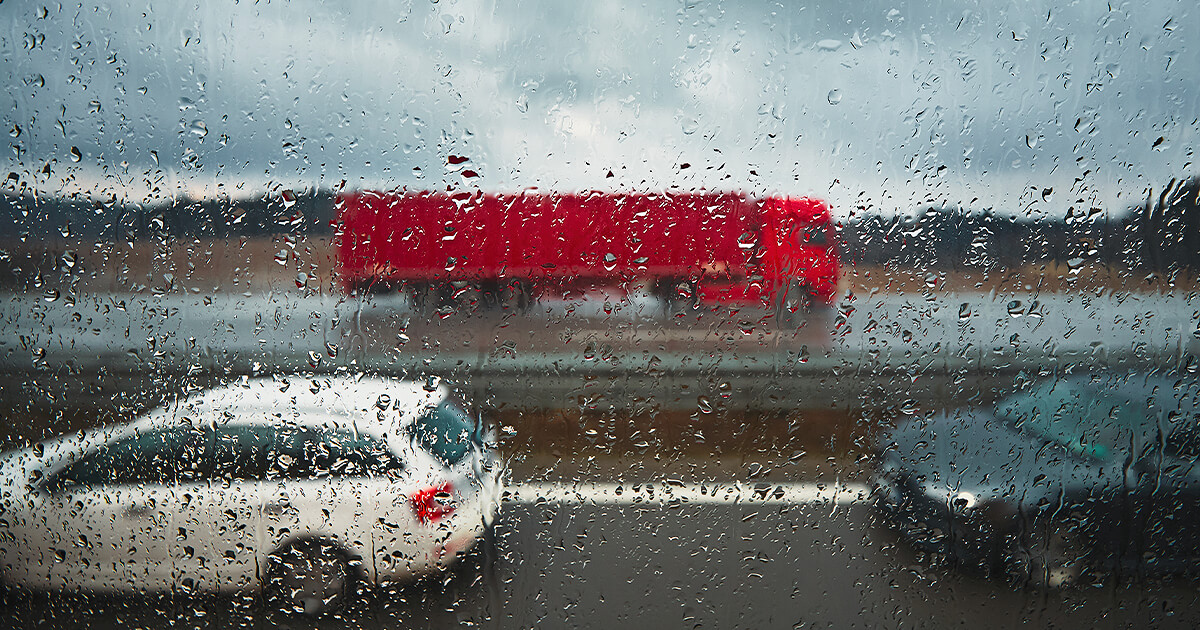 Red truck driving in the rain while moving house