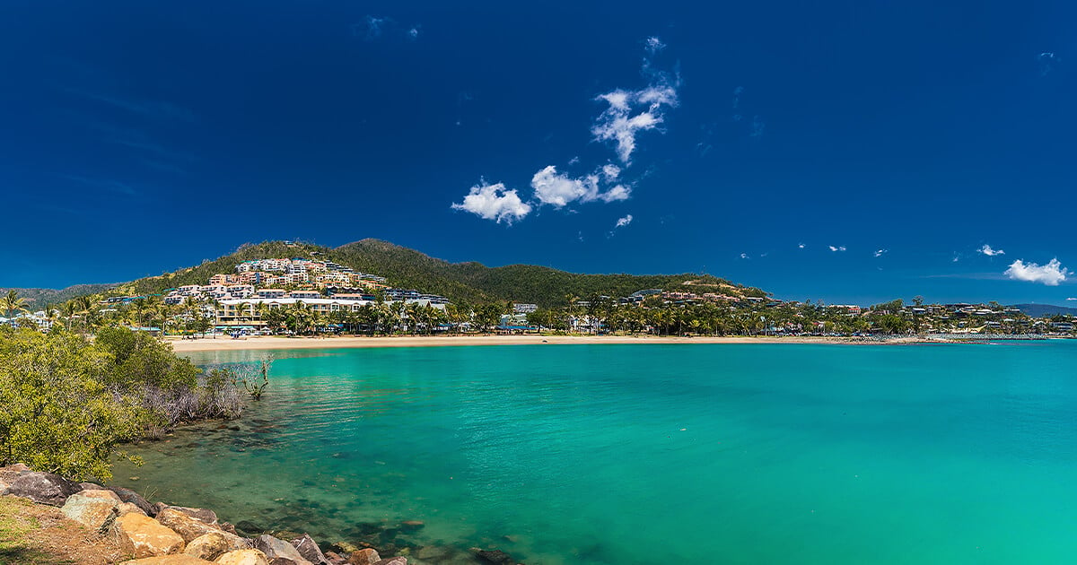 Tropical beach with houses built on hill overlooking the beaches