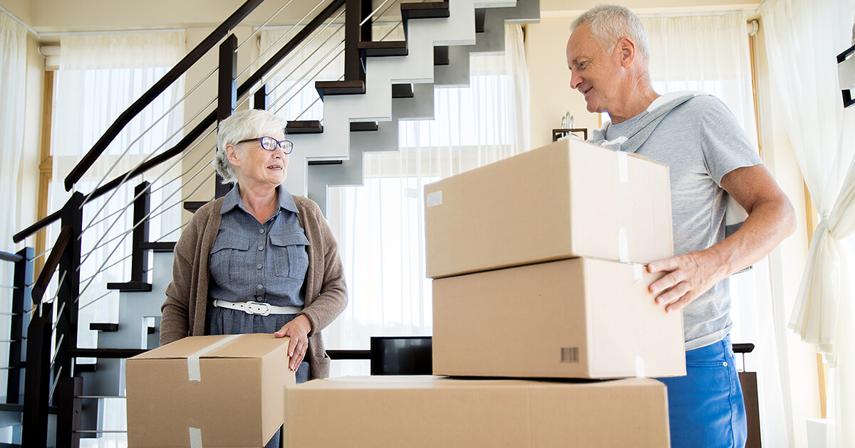 Senior couple moving boxes ready for removalist to move their home