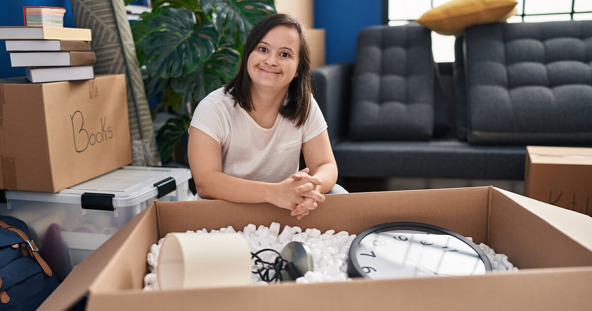 Woman with down syndrome packs boxes ready to move home