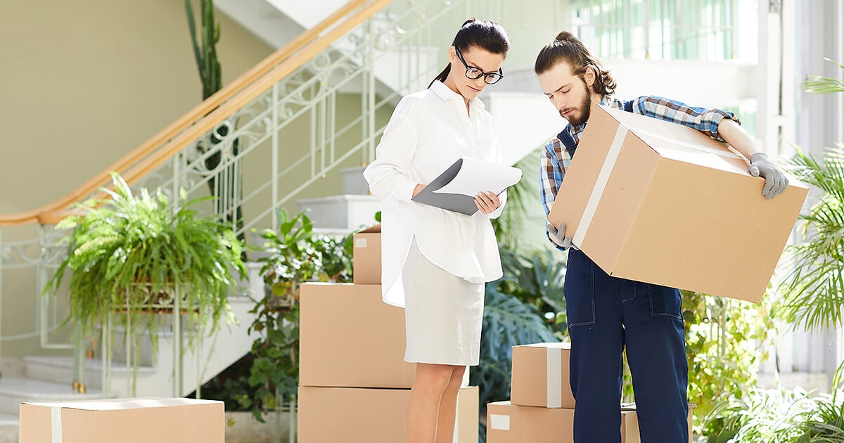 Office move manager looks at plan with removalist