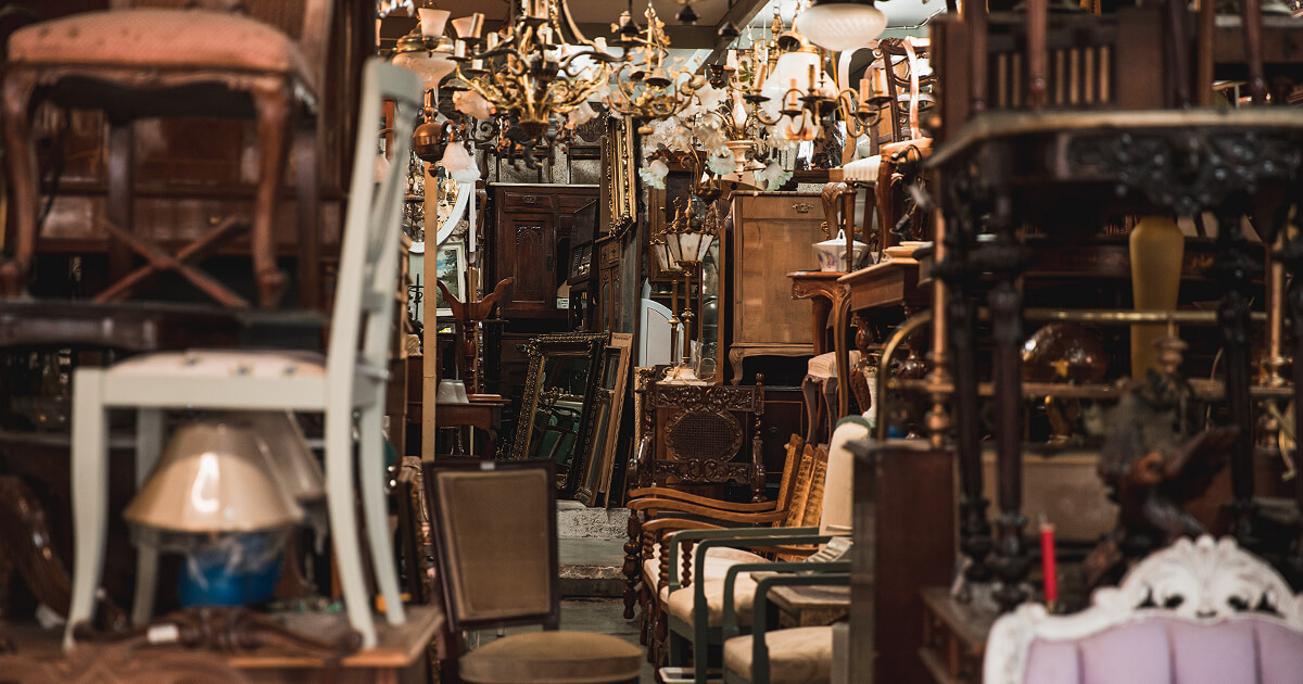 Looking down a corridor in op shop with old furniture either side