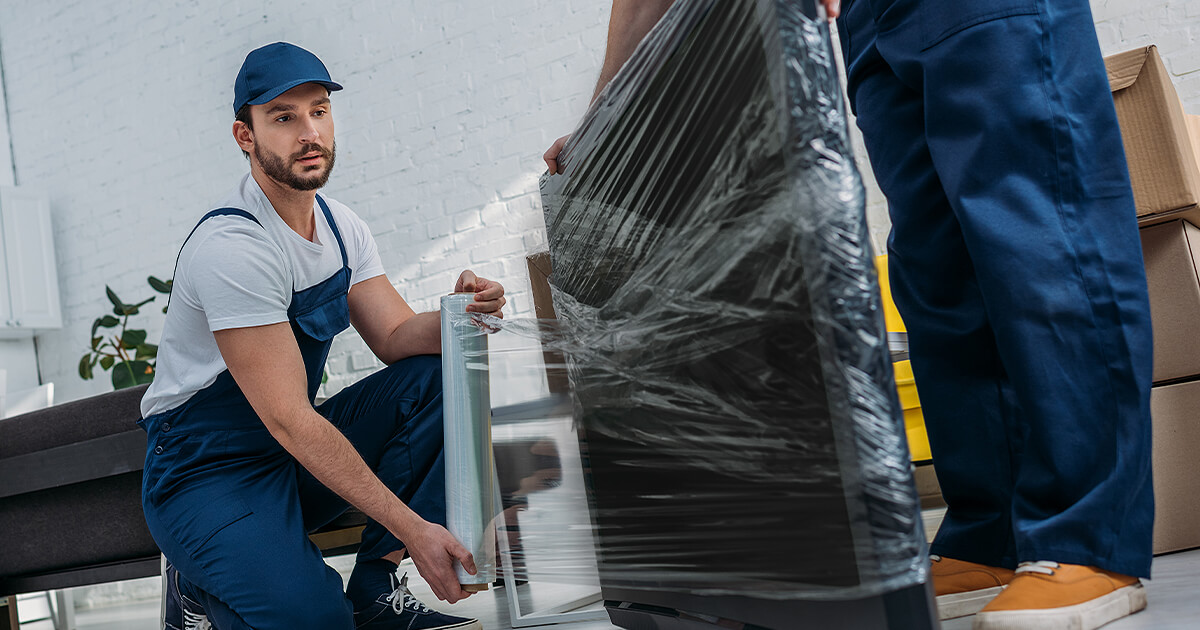 Removalist wraps tv in packaging to protect it during transport 
