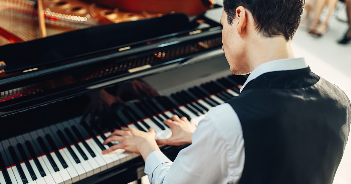 Overhead view of man playing piano after being moved by piano removalists Brisbane
