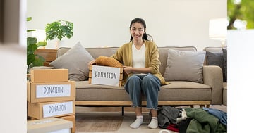 Woman sitting on couch with donation boxes