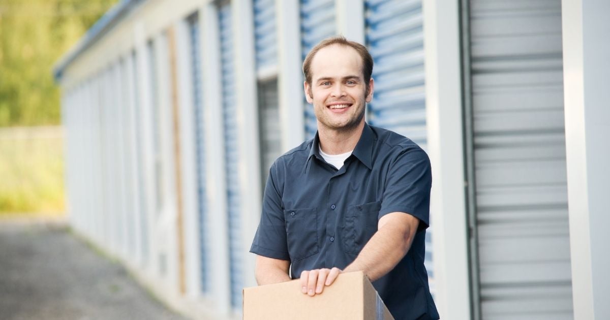 man holding box outside of storage place