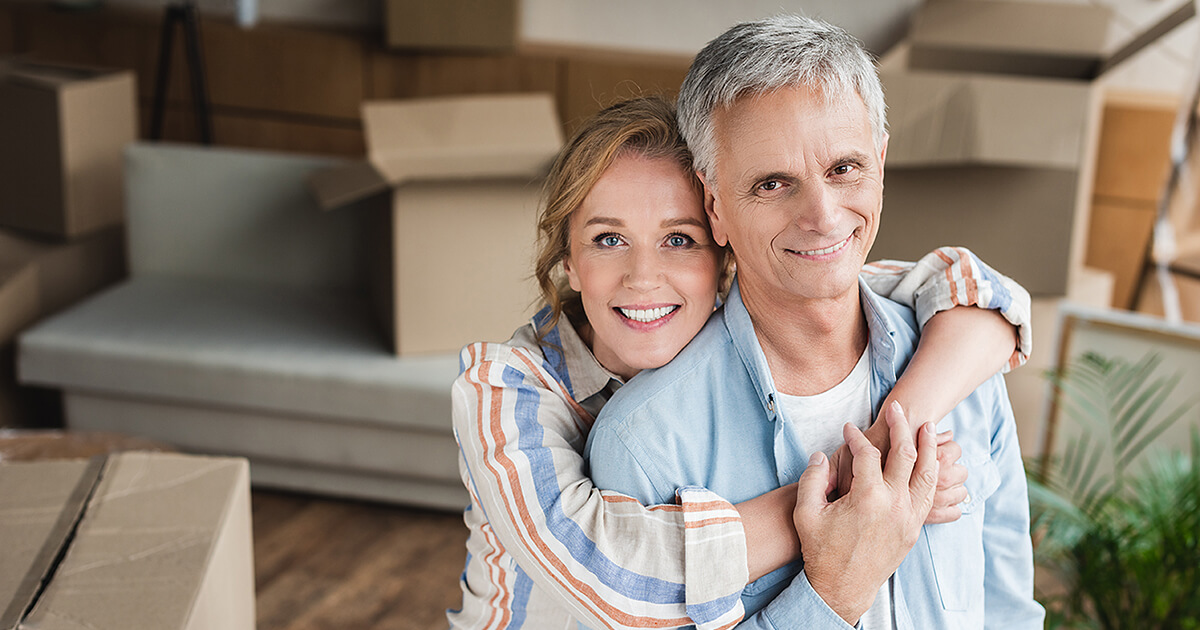 Happy seniors hugging while getting ready to move to Brisbane.