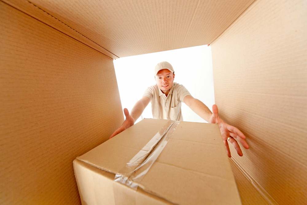 Moving man grabbing a package from inside a box