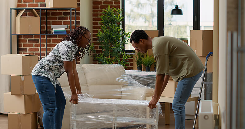 A couple wrapping furniture for donation