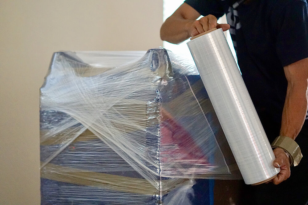 furniture being wrapped in plastic before storage