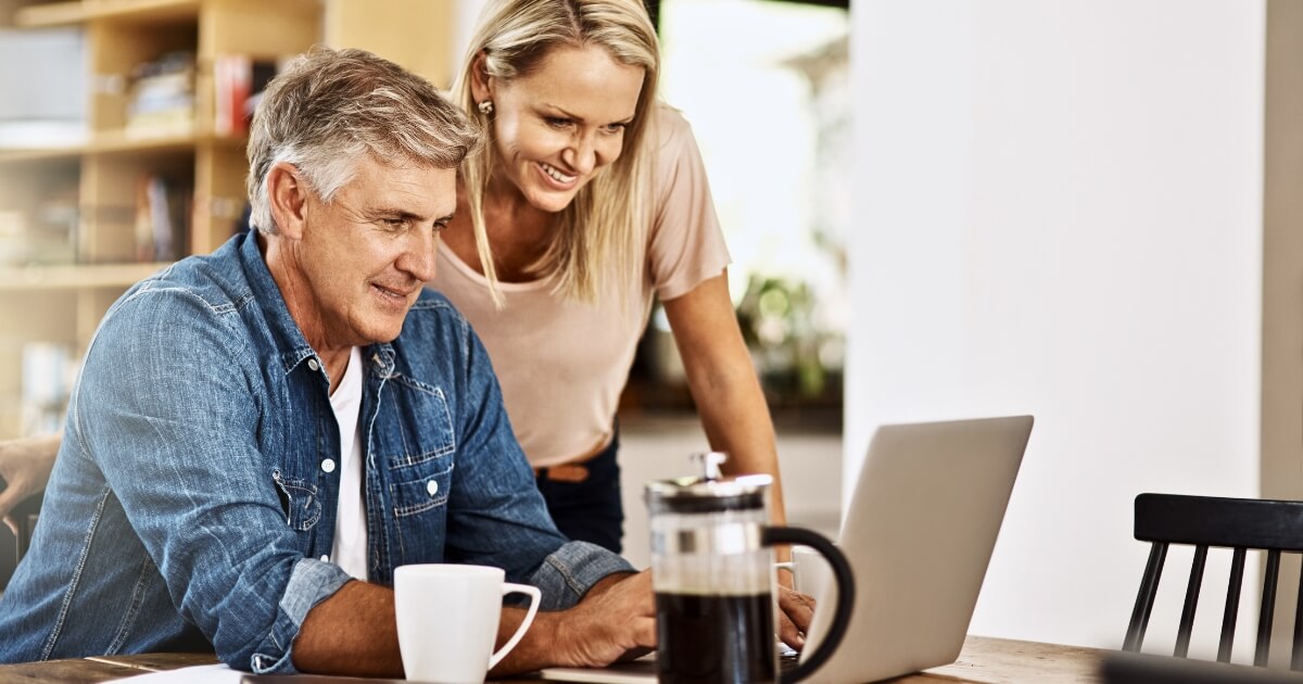 Happy couple researching housing hotspots in Australia by computer