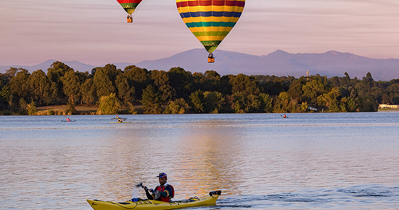 Kayaking in Canberra with balloons in the background