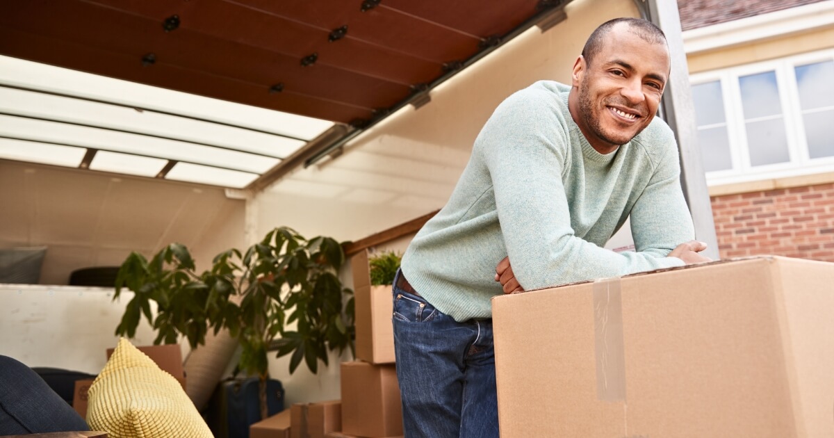 Man leaning on moving boxes during his interstate move