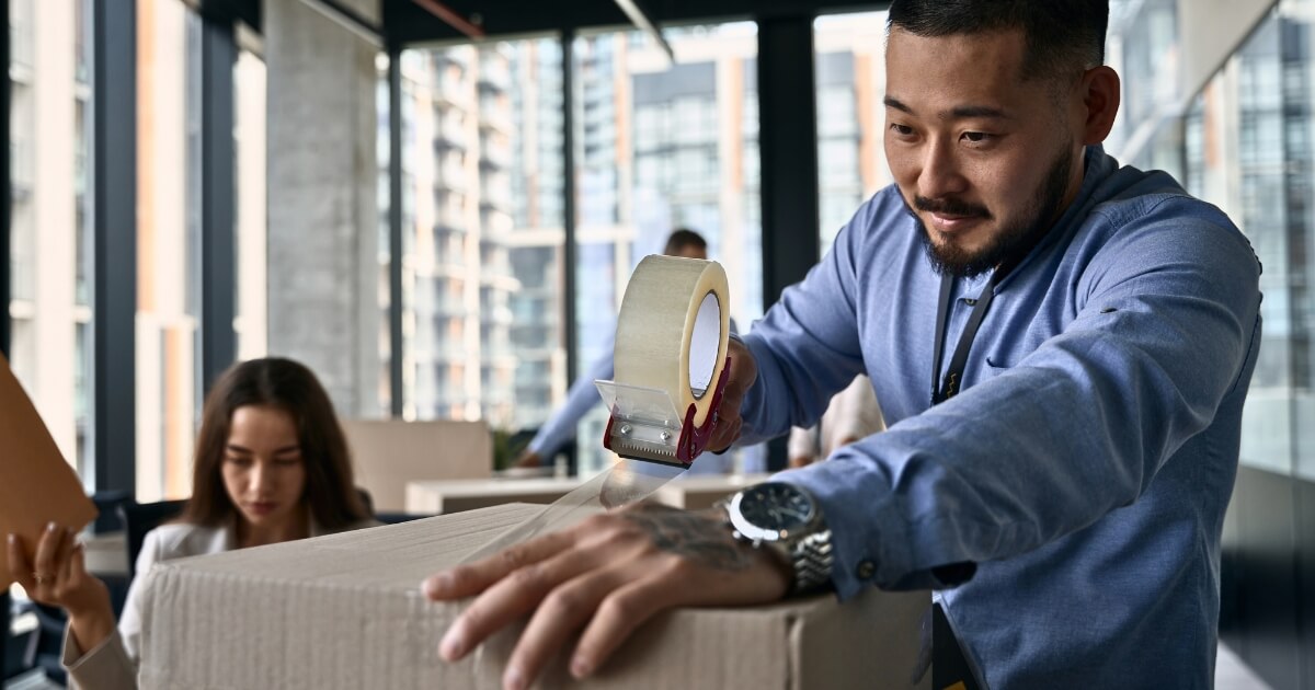 Man taping a box for an office removal
