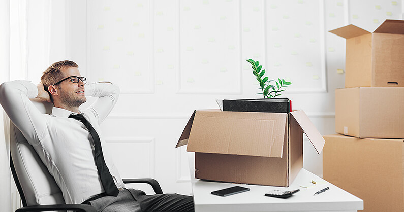 Man relaxing in office with moving boxes when working for professional office movers