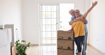 happy retired couple with packed boxes moving house