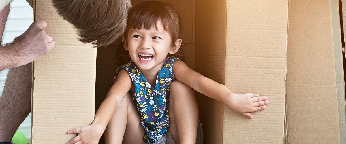 Toddler girl playing in box