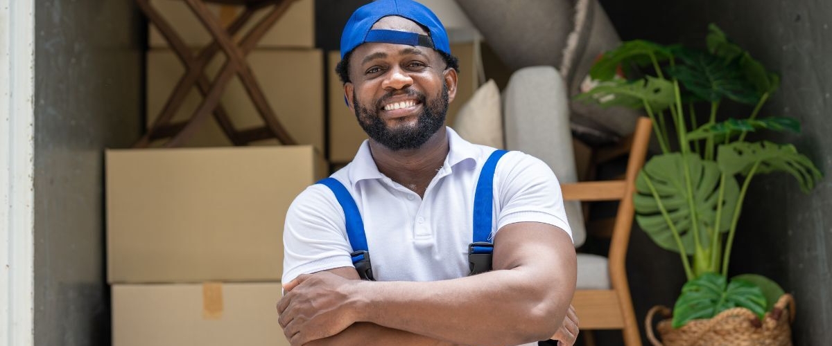 Happy removalist in front of truck