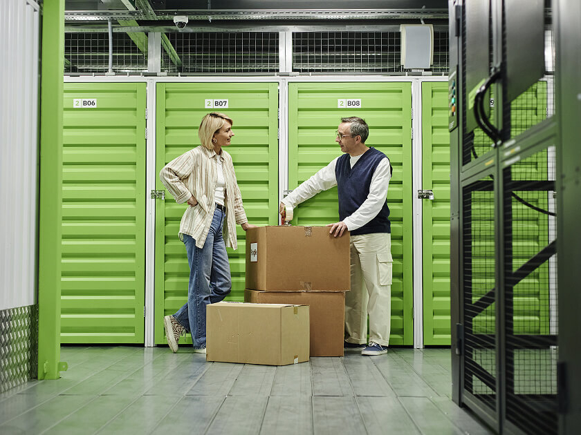 People standing outside of storage with boxes