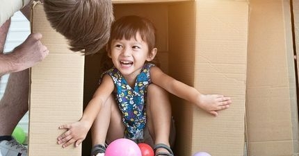 Toddler girl playing in box